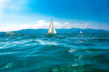 Segelboot auf dem Bodensee, entspannte, gelassene Sommerstimmung mit Wellen, und blauen Himmel - obrazy, fototapety, plakaty