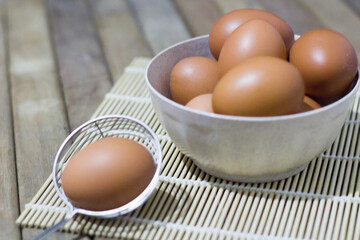 Brown eggs in bowl on a rustic wooden background with copy space. Selective focus