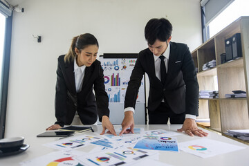 Businessman  and woman hands working with finance marketing chart and Business teamwork and working on digital laptop computer with advisor showing plan of investment to clients at table office.  