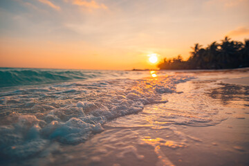 Fantastic closeup view of calm sea water waves with orange sunrise sunset sunlight. Tropical island...