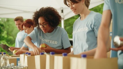 Group of Volunteers Preparing Free Food Rations for Poor People in Need. Charity Workers and Members of the Community Work Together. Concept of Giving, Humanitarian Aid and Society. Static Shot.