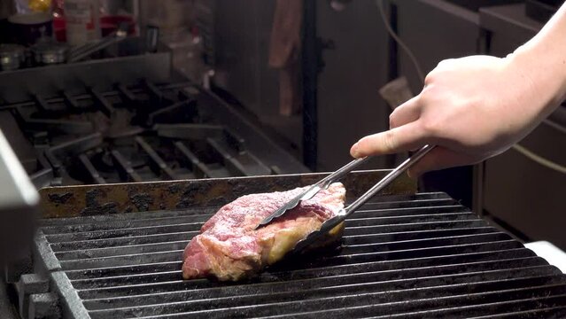 溶岩石チャコールの上で香ばしく焼き上げる牛ステーキの、肉厚でジューシーな質感を閉じ込めた「調理動画」。溢れる肉汁の輝きと焼き色が際立つシーンで、ステーキハウスや炭火焼メニューの販促に最適な高品質素材です。 | Grilling a thick beef steak on lava stone charcoal with sizzling meat juices.