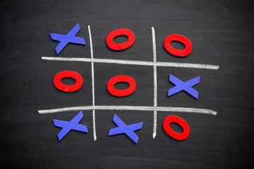 Abstract Tic Tac Toe Game Competition with Wood Alphabet letters. XO Win Challenge Concept on black board.