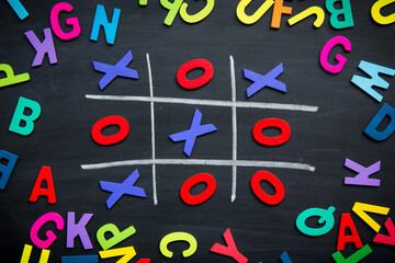 Abstract Tic Tac Toe Game Competition with Wood Alphabet letters. XO Win Challenge Concept on black board.