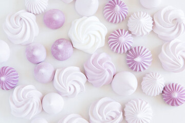 Flat lay with purple, airy,  delicate meringue on white background. 