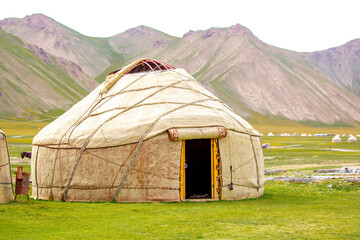 Yurt. National old house of the peoples of Kyrgyzstan and Asian countries. national housing. Yurts on the background of green meadows and highlands. Yurt camp for tourists.