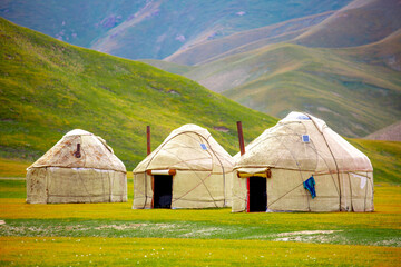 Fototapeta na wymiar Yurt. National old house of the peoples of Kyrgyzstan and Asian countries. national housing. Yurts on the background of green meadows and highlands. Yurt camp for tourists.