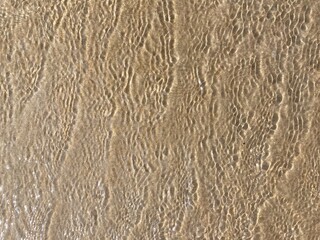 Sunlight creates a pattern on a wavy water surface