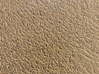 Sunlight creates a pattern on a wavy water surface