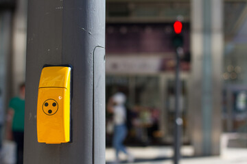 Pedestrian crossing button with red light on traffic light