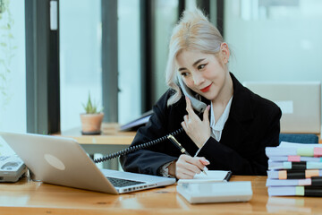 Friendly cheerful asian businesswoman smiling, people emotions and casual concept, positive woman working in office workspace.