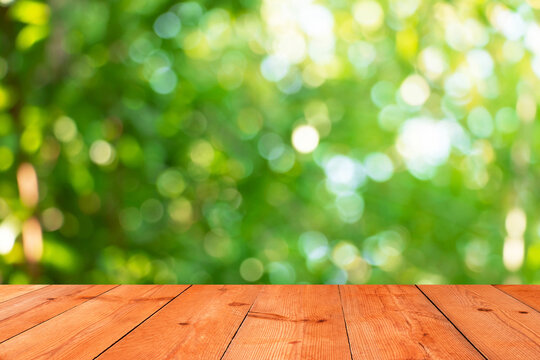perspective wooden board over blurred leaves bokeh