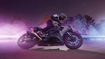 Obraz na płótnie Canvas Moto rider making a stunt on his motorbike. Biker doing a difficult and dangerous stunt.