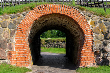 Stone arch and tunnel in the fortress wall. Vintage building background.