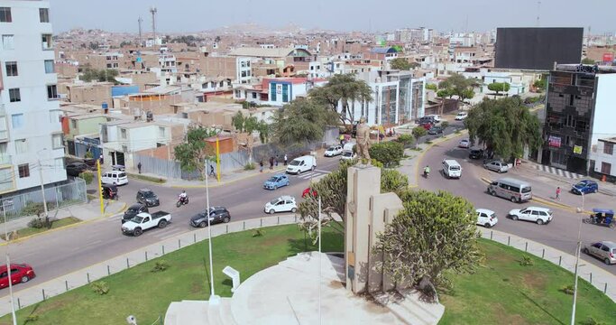 Beautiful drone shot over the famous "Ovalo Qui&ntilde;ones" oval on the highway of the city of Chiclayo, Peru while cars drive around during the afternoon.