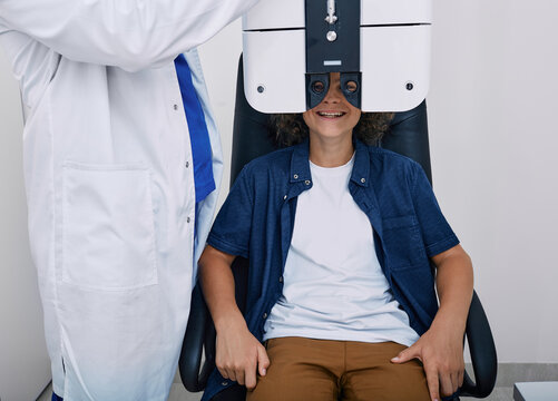 Teenager boy has eye test in ophthalmological clinic using phoropter. Eye test for children, vision diagnostic