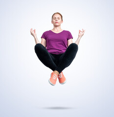 Young woman in casual clothes with her eyes closed is relaxed levitating in the air in the lotus...