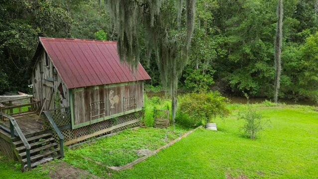 Aerial view of small barn hear an old oak tree with Spanish moss