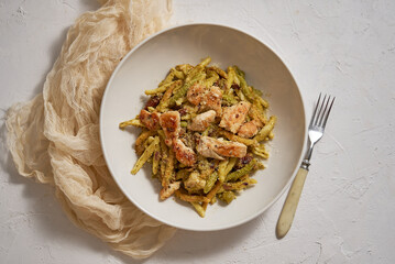 A delicious grilled chicken and pasta dumplings with pesto. Dinner on a white plate