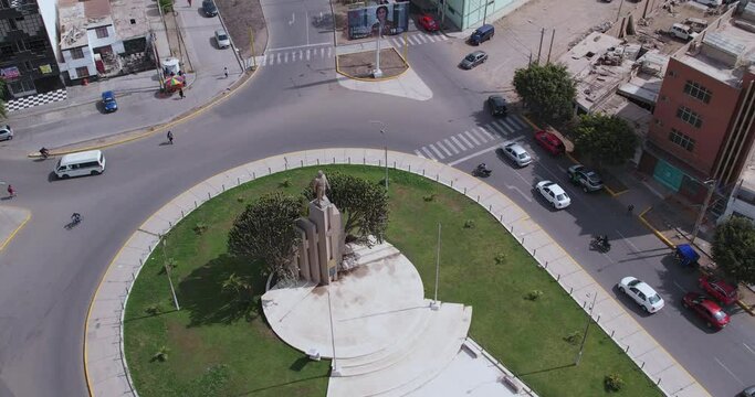 Beautiful drone shot rotating over the famous "Ovalo Qui&ntilde;ones" oval on the highway of the city of Chiclayo, Peru while cars and people pass by during the day.