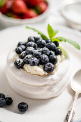 Delicious mini Pavlova meringue nest with blueberry and mint leaves