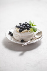Delicious mini Pavlova meringue nest with blueberry and mint leaves