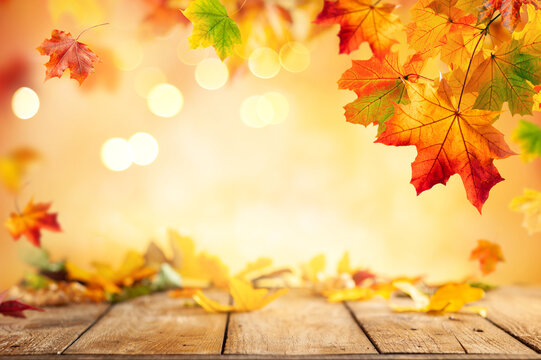  Wooden table and blurred Autumn background. Autumn concept with red-yellow leaves background.