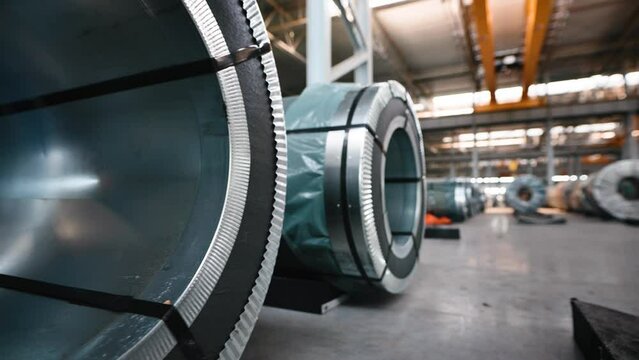 Industrial workshop and warehouse for storage and distribution of products of a metallurgical plant. Coiled steel is stored in rows in a modern warehouse.