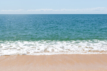 Fototapeta na wymiar Turquoise sea waves splashing on sand shore