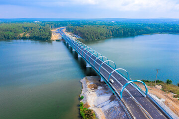 Fototapeta premium Flight over new modern road bridge across river. Bridge has night illumination