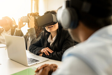 Multi-ethnic creative business team using virtual reality headsets in meeting in modern office. focus on asian woman