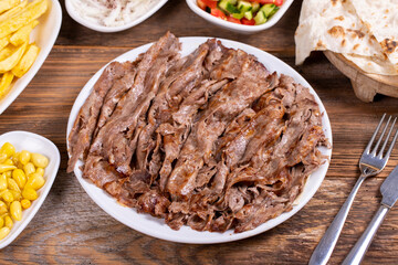 Meat doner kebab on the plate. Turkish meat doner kebab on wooden background. Traditional Turkish cuisine. close up