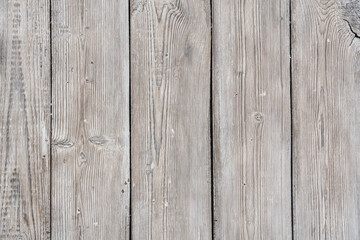 Old wooden boards arranged vertically are painted with white paint while preserving the texture of wood