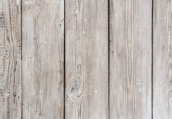 Old wooden boards arranged vertically are painted with white paint while preserving the texture of wood