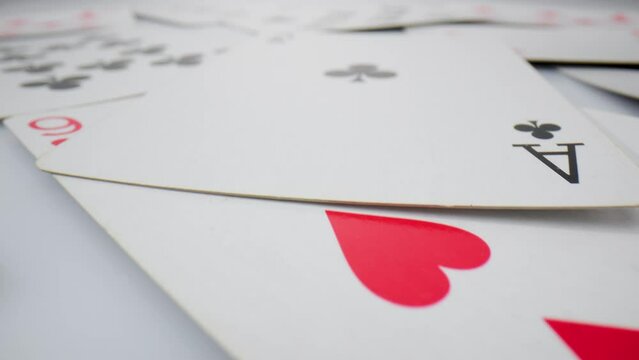Playing cards on the white bacground. Extremely close-up detailed, randomly lying playing cards of the red suit of hearts and diamonds.