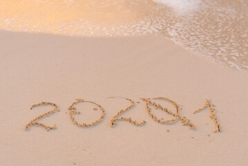 handwritten inscription 2021 on the sand by the sea