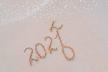 handwritten inscription 2021 on the sand by the sea