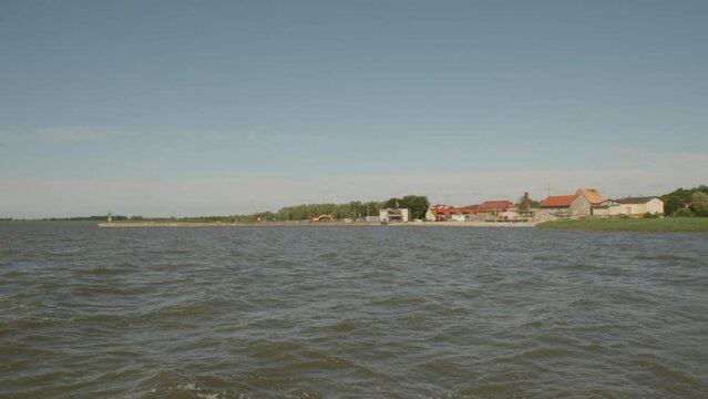 Distant View Of Coastal Town Of Frombork Across The Vistula Lagoon In Braniewo County, Poland. wide, slow motion