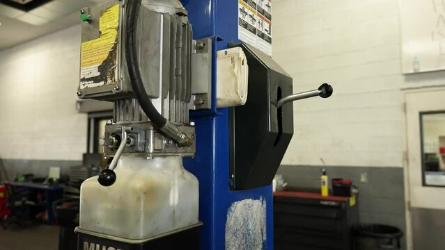 Hydraulic lift mechanism to raise and lower car. Repair center car garage for service. Shot on 4k SONY A7SIII