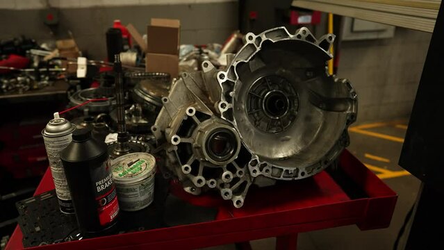 Car transmission being repaired, panning shot. Repairman technician car service center garage. Shot on 4k SONY A7SIII.