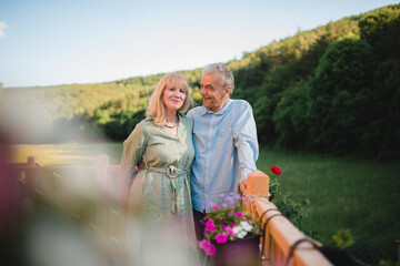 Portrait of affectionate senior couple spending time together in garden at home.