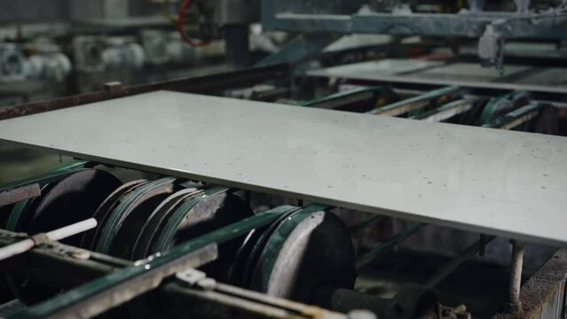 Factory for the production of ceramic tiles and porcelain tiles. Automatic conveyor in the workshop.