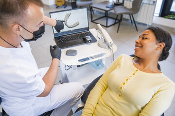 Dentist and patient choosing treatment in a consultation with medical equipment