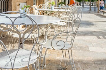 Vintage white tables and chairs on the terrace of a coffee shop