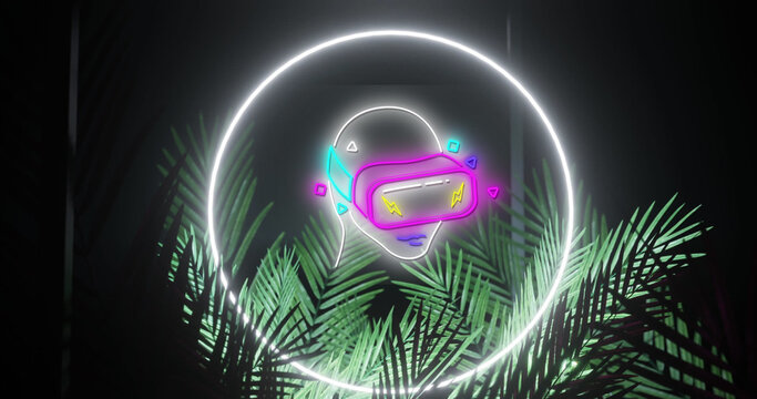 Image of neon head in vr headset and ring in white neon, over palm leaves on black background