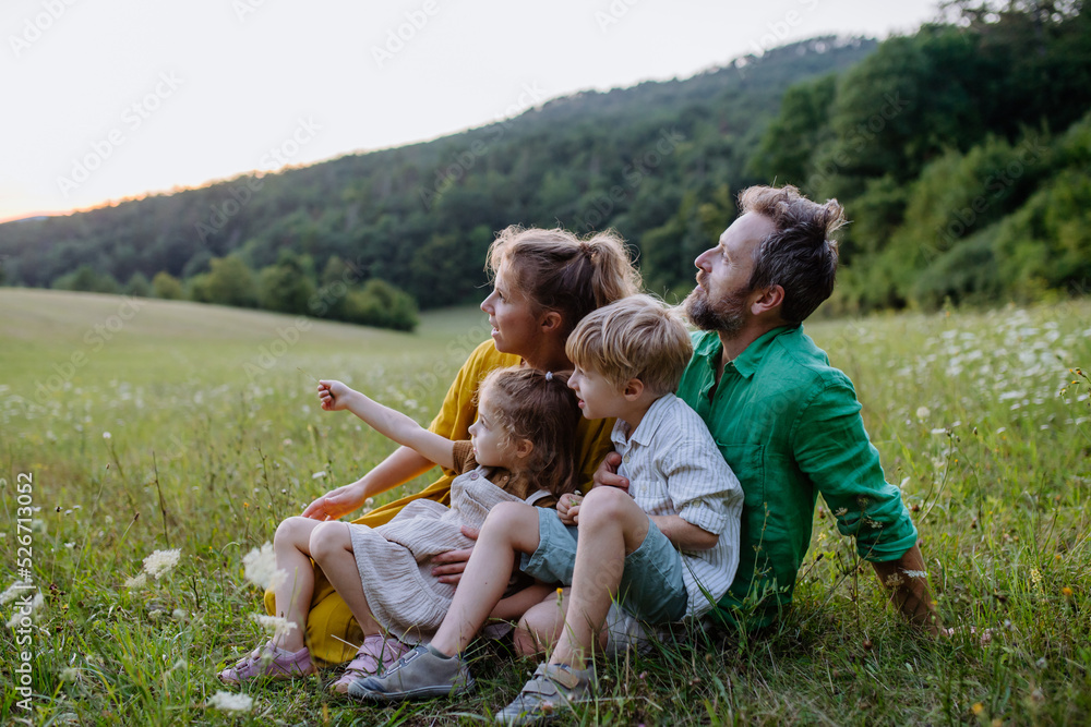 Wall mural Happy young family spending time together outside in green nature.