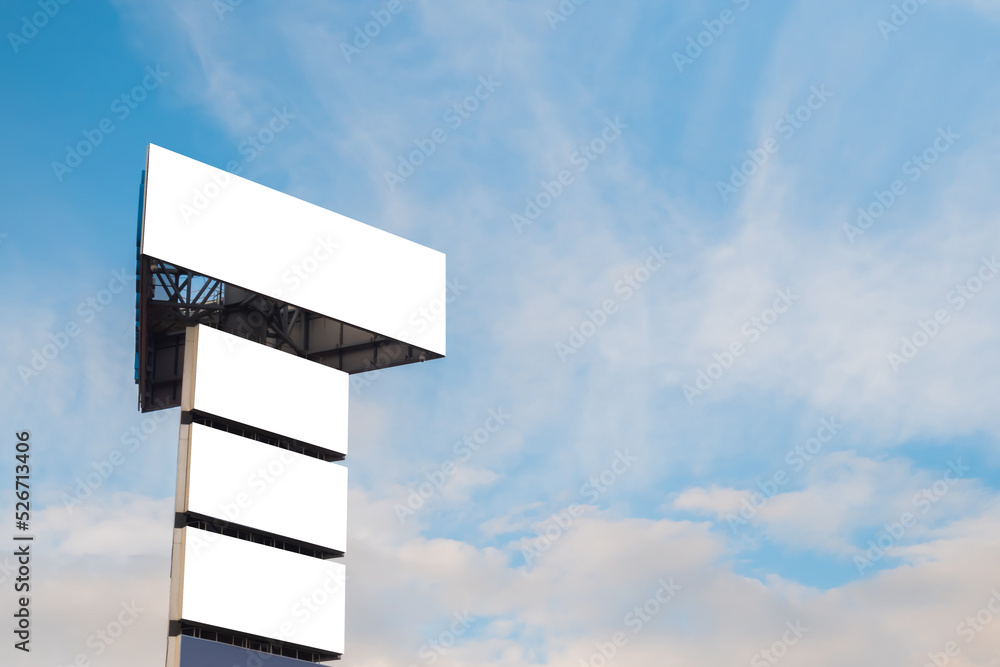 Canvas Prints mock up image: four blank white billboards or large displays on tower against blue sky with clouds. 