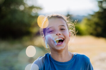 Portrait of a beautiful little girl laughing when having fun in summer in nature.