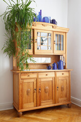 Vintage pine cupboard with glass and wooden doors, drawers, blue vases and jugs