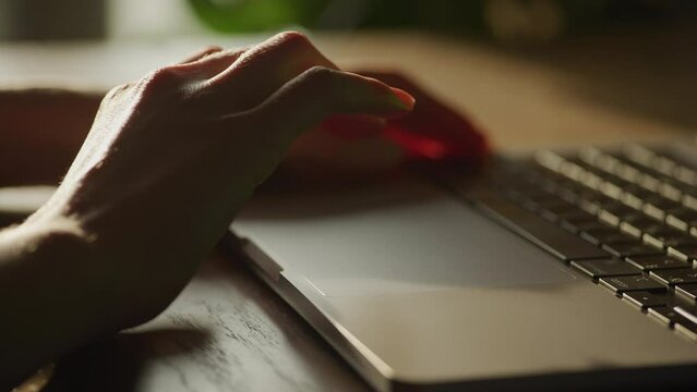 Close up of a caucasian woman hands sroll or swipe on a laptop computer touchpad